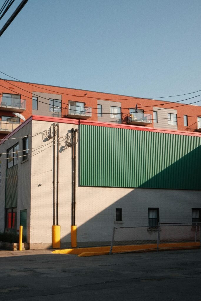 Commercial building with a green facade in Montreal under clear blue sky.